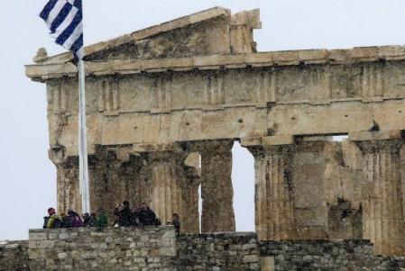 Tourists take photos atop the Athens Acropolis during a snowstorm